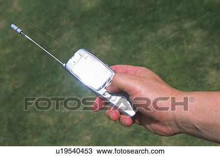 Stock Image - Holding a Mobile Phone, High Angle View. Fotosearch