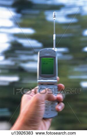 Stock Image - Holding a Mobile Phone, Low Angle View. Fotosearch