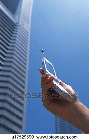 Stock Image - Holding a Mobile Phone, Low Angle View. Fotosearch