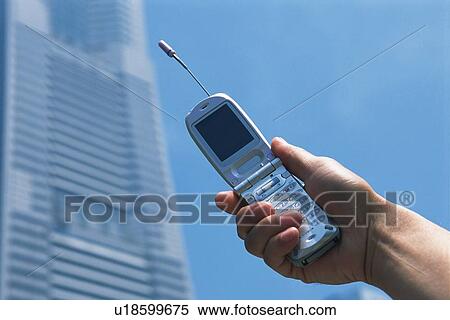 Stock Photography - Holding a Mobile Phone, Low Angle View. Fotosearch
