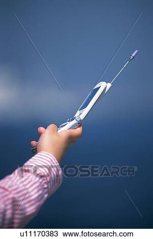 Stock Image - Holding a Mobile Phone, Side View. Fotosearch