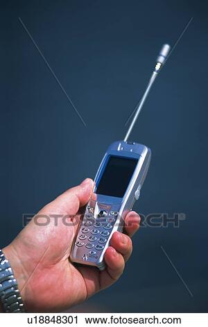 Stock Image - Holding a Mobile Phone, Side View. Fotosearch