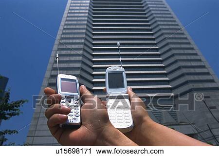 Two People Holding a Mobile Phone, Low Angle View View Large Photo Image Stock Image - Two People Holding a Mobile Phone, Low Angle View. Fotosearch