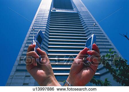 Two People Holding a Mobile Phone, Low Angle View View Large Photo Image Stock Photograph - Two People Holding a Mobile Phone, Low Angle View. Fotosearch