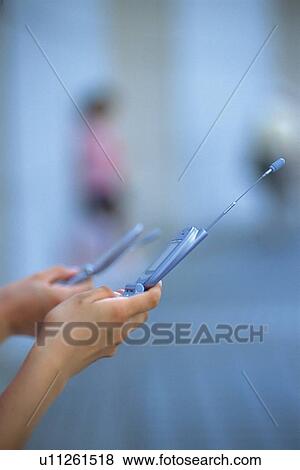 Two People Holding a Mobile Phone, Side View View Large Photo Image Stock Photo - Two People Holding a Mobile Phone, Side View. Fotosearch