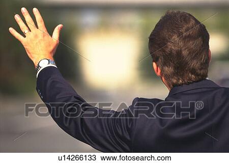 Stock Image - Businessman raising hand up, Rear View. Fotosearch