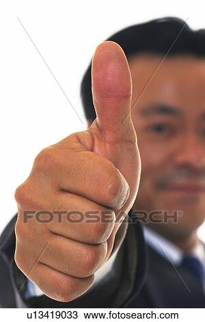 Stock Image - Businessman raising thumb up in the air, Close Up, Pin Focus. Fotosearch