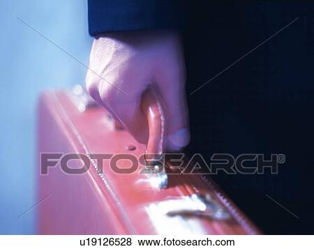 Stock Photo - Hand holding a business case, Close Up. Fotosearch