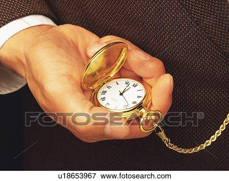 Stock Photo - Hand holding a fob watch, Close Up, High Angle View. Fotosearch