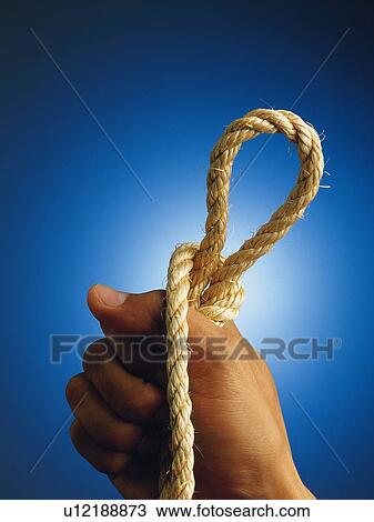 Stock Image - Hand holding a tied rope, Close Up. Fotosearch