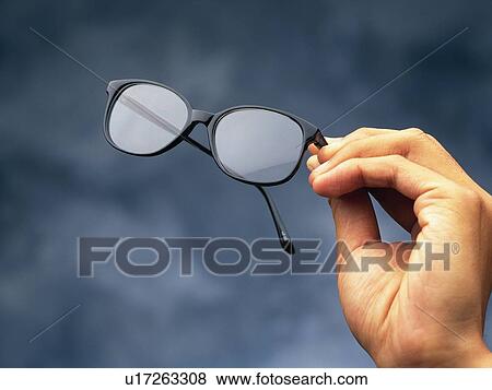 Stock Photo - Hand holding glasses, Close Up. Fotosearch