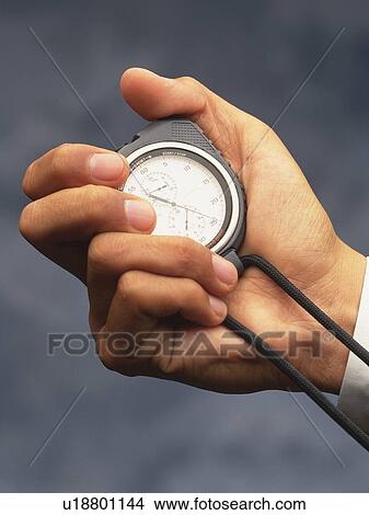 Hands holding a stop watch, Close Up, High Angle View View Large Photo Image Picture - Hands holding a stop watch, Close Up, High Angle View. Fotosearch