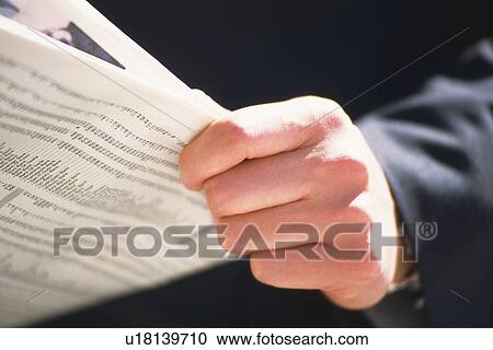Stock Image - Hands holding news paper, Close Up. Fotosearch
