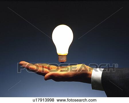 Light bulb floating above hand, Side View View Large Photo Image Stock Photo - Light bulb floating above hand, Side View. Fotosearch