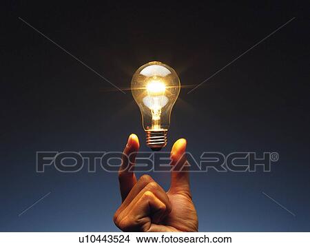 Light bulb floating between fingers, Front View View Large Photo Image Picture - Light bulb floating between fingers, Front View. Fotosearch