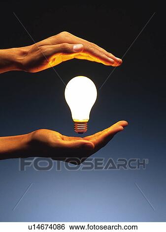Stock Photograph - Light bulb floating in hands, Side View. Fotosearch