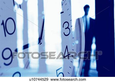 Stock Photo - Businessman and image of clock, CG, composition, soft focus. Fotosearch
