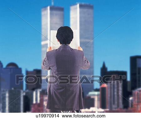 Picture - Businessman holding newspaper and image of buildings, rear view, CG, composition. Fotosearch