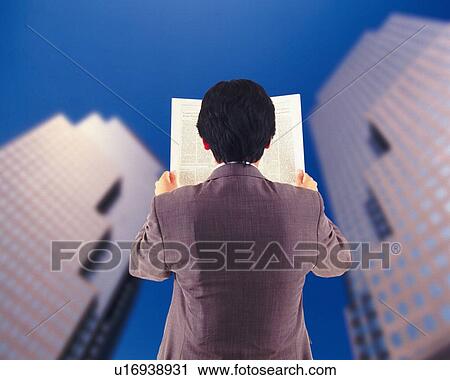 Stock Image - Businessman holding newspaper and image of buildings, rear view, CG, composition. Fotosearch