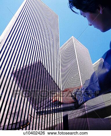 Businessman using laptop and image of buildings, CG, composition View Large Photo Image Stock Photograph - Businessman using laptop and image of buildings, CG, composition. Fotosearch