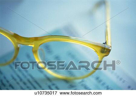 Stock Photo - Glasses on newspaper, high angle view, close up, soft focus. Fotosearch