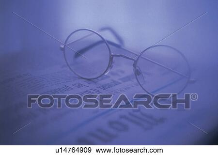 Stock Photo - Glasses on newspaper, high angle view, close up, soft focus. Fotosearch