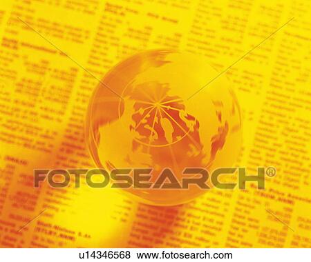 Stock Photo - Globe on newspaper, high angle view, close up, soft focus, toned image. Fotosearch