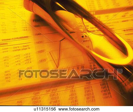 Stock Photograph - Hourglass on financial press, blurred motion, toned image, high angle view. Fotosearch