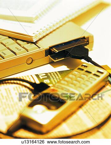 Mobile phone being connected to laptop, high angle view, close up View Large Photo Image Stock Photograph - Mobile phone being connected to laptop, high angle view, close up. Fotosearch