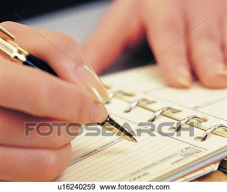 Stock Photo - Woman writing down on personal organizer, close up. Fotosearch