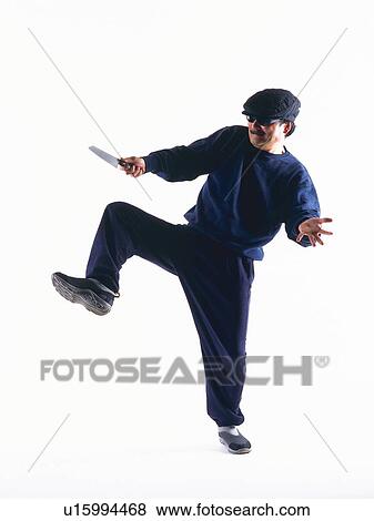Stock Photo - Burglar threatening with a knife, Front View. Fotosearch