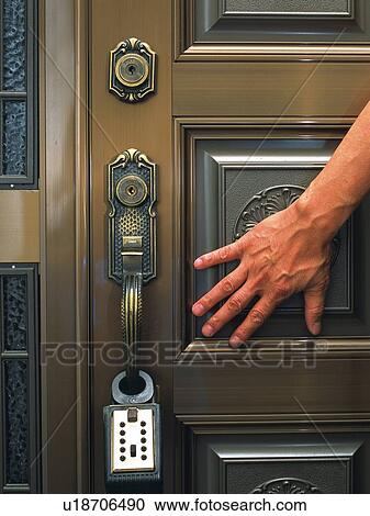 Stock Image - Hand and the door lock, Crime Image, Front View. Fotosearch