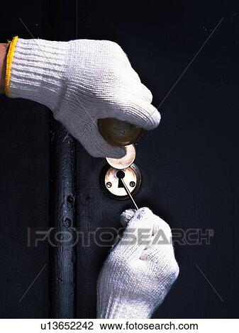 Stock Image - Hands unlocking the door with a key, Crime Image, Close Up. Fotosearch