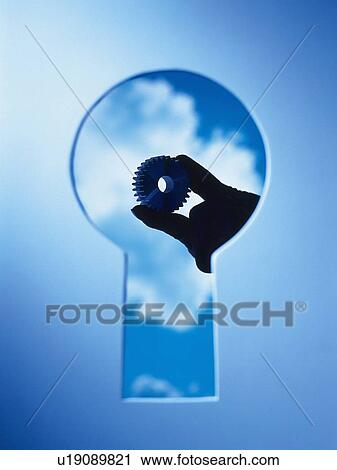 Stock Image -  Key hole and a hand with a gearwheel behind, Composite, Toned Image. Fotosearch