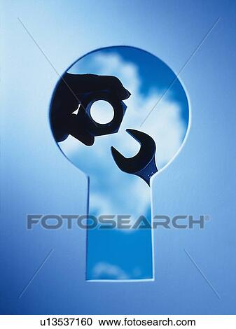 Stock Image -  Key hole and a hand with tools behind, Composite, Toned Image. Fotosearch