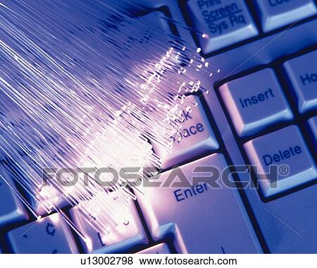 Stock Photo - Bunch of illuminated fiber optics on computer keyboard, close up, high angle view. Fotosearch
