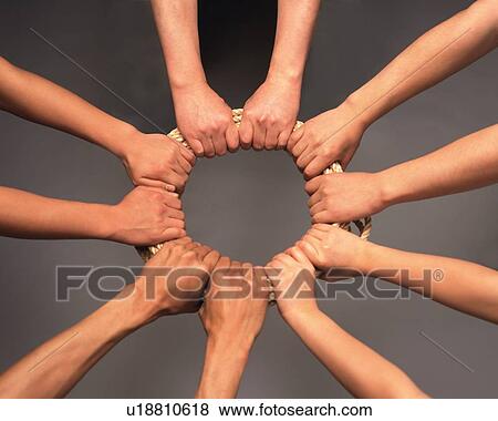 Stock Photo - Five people grasping rope in circle, high angle view. Fotosearch