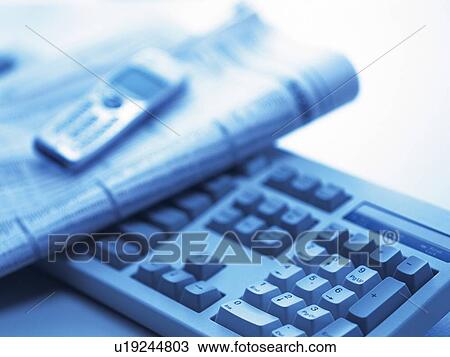 Stock Image - Keyboard, Newspaper and Mobile Phone, Close Up, Blurred, Toned Image. Fotosearch