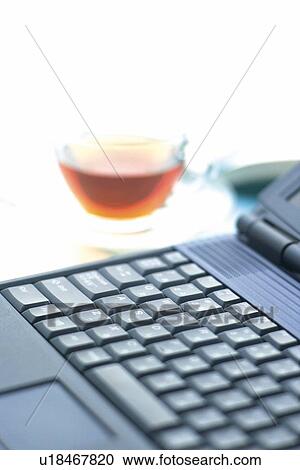 Stock Image - Personal Computer and Tea on the Desk, Close Up. Fotosearch