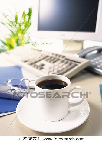 Stock Image - Cup of tea and computer, Pin Focus, High Angle View. Fotosearch
