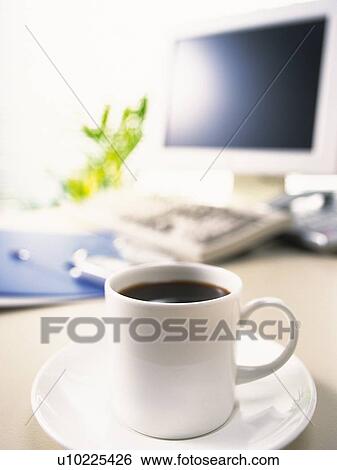 Stock Photograph - Cup of tea and computer, Pin Focus, High Angle View. Fotosearch