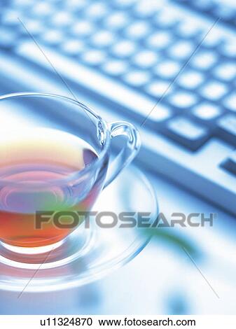 Stock Image - Cup of tea and keyboard, Pin Focus, High Angle View. Fotosearch