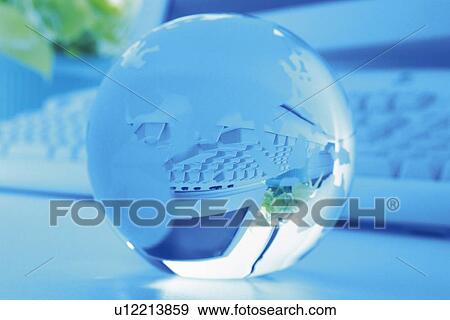 Stock Photo - Glass globe and computer, Close Up, Pin Focus, Toned Image. Fotosearch