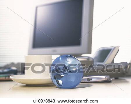Stock Image - Glass globe and computer, Pin Focus. Fotosearch