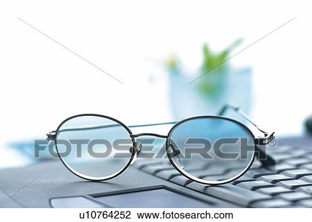 Stock Image - Glasses on a laptop computer, Pin Focus. Fotosearch
