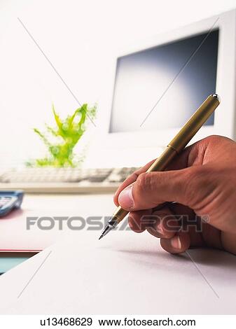 Stock Photo - Hand writing down with a pen, Pin Focus, Low Angle View. Fotosearch