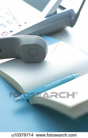 Picture - Handset and a notebook, Pin Focus, High Angle View. Fotosearch