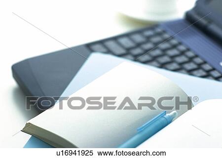 Stock Photography - Laptop computer and a notebook, Pin Focus, High Angle View. Fotosearch