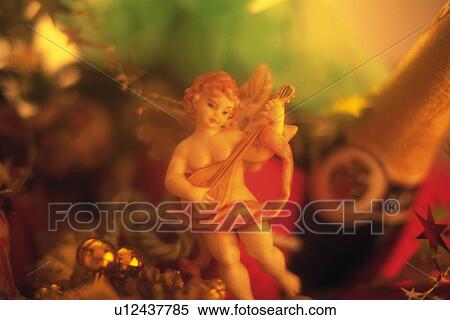 Angel with Christmas ornaments and champagne bottle, front view, soft focus View Large Photo Image Stock Photography - Angel with Christmas ornaments and champagne bottle, front view, soft focus. Fotosearch