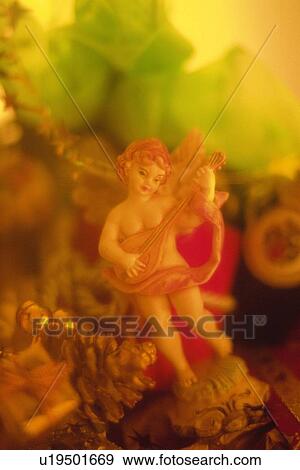 Stock Photo - Angel with Christmas ornaments, front view, soft focus. Fotosearch
